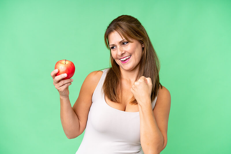 Fresh green apples next to dental tools, symbolizing oral health and gum care.