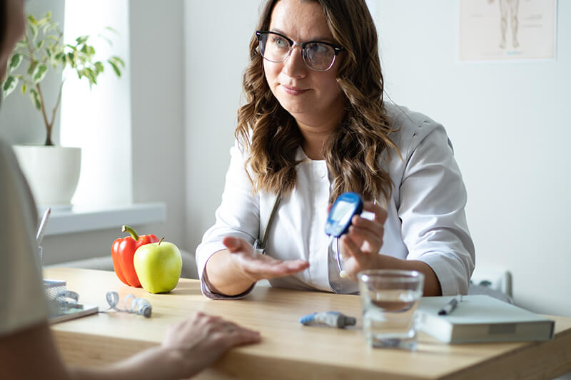Doctor showing patient how to use a glucometer