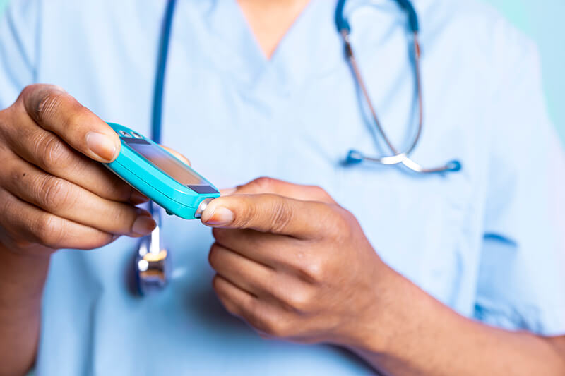 Healthcare worker measuring blood sugar level with finger puncture