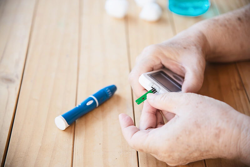 Elderly woman using a kids test kit to check blood sugar levels
